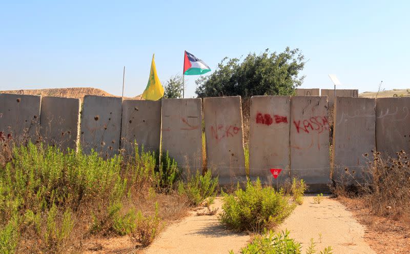 Palestinian and Hezbollah flags are seen in Houla village near the Lebanese-Israeli border