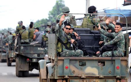 Member of the Philippine Marine Battalion Landing Team (MBLT) wave at residents and motorists while in a military truck as they travel their way back from their five-month combat duty against pro-Islamic State militant groups, a few days after President Rodrigo Duterte announced the Liberation of Marawi city, southern Philippines October 21, 2017. REUTERS/Romeo Ranoco