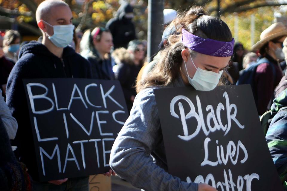 Demonstrators observe a minute's silence in Canberra in memory of George Floyd. NSW police are seeking to make further Black Lives Matter protests illegal (AP)