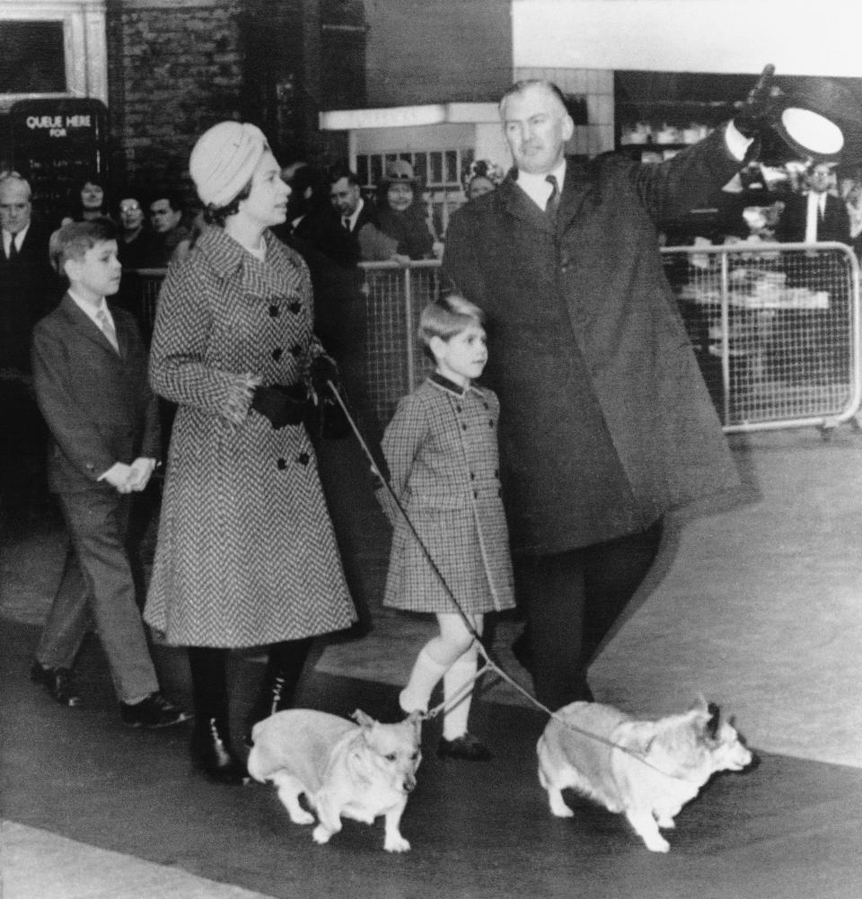 FILE - Britain's Queen Elizabeth II is accompanied by two of her sons, 10-year-old Prince Andrew, left, and Prince Edward, 6, and two of the royal corgis as she talks with unidentified official at London's Liverpool street railway station on Dec. 30, 1970. Queen Elizabeth II's corgis were a key part of her public persona and her death has raised concern over who will care for her beloved dogs. The corgis were always by her side and lived a life of privilege fit for a royal. She owned nearly 30 throughout her life. She is reportedly survived by four dogs. (AP Photo/ John Rider)