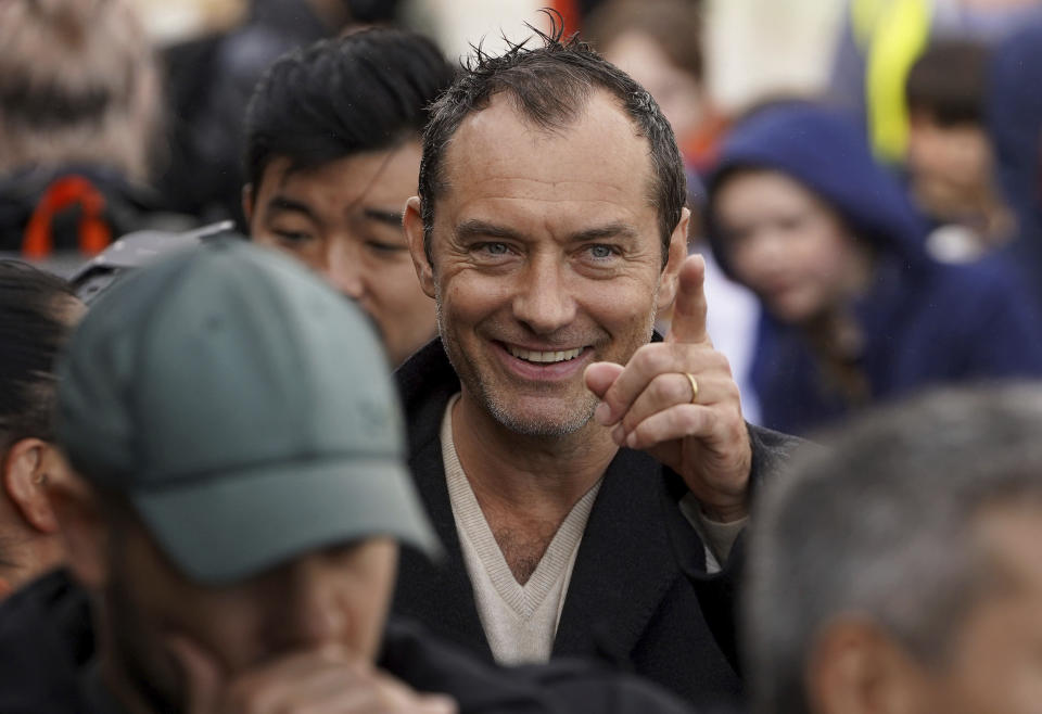 Actor Jude Law attends the arrival of Little Amal, a 3.5-meter-tall puppet of a nine-year-old Syrian girl, as it arrives at Folkestone Beach, Kent, Tuesday, Oct. 19, 2021 as part of the Handspring Puppet Company's 'The Walk'. The puppet started her journey in Turkey on 27 July and has travelled nearly 8,000 km across Greece, Italy, Germany, Switzerland, Belgium and France, symbolizing millions of displaced children. (Gareth Fuller/PA via AP)