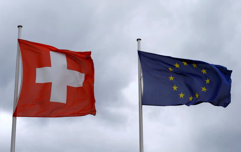 FILE PHOTO: An EU flag flies beside Switzerland's national flag near the German-Swiss border in Rheinfelden