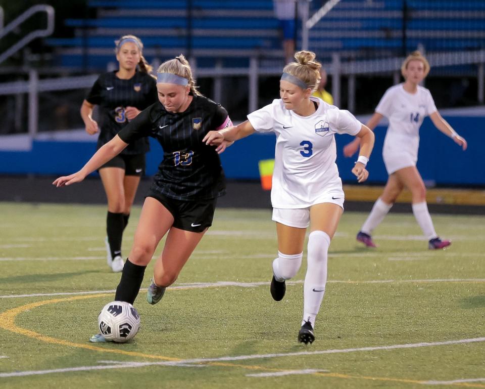 Olentangy's Audrey Oliver (left) tries to advance the ball under pressure from Olentangy Liberty's Teigan Casey in the season opener Aug. 12.