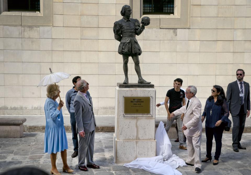 FILE - In this March 25, 2019 file photo, Havana City Historian Eusebio Leal Spengler, front right, unveils a statue of William Shakespeare during a visit by Britain's Prince Charles, the Prince of Wales, second from left, and his wife Camilla, Duchess of Cornwall, as he gives a guided tour of the historic area of Havana, Cuba. Leal, who oversaw the transformation of crumbling Old Havana to an immaculately restored colonial tourist attraction, becoming the de-facto mayor of the historic city center and one of the nation’s most prominent public intellectuals, has died according to state media on Friday, July 31, 2020, after a long battle with cancer. (AP Photo/Ramon Espinosa, File)