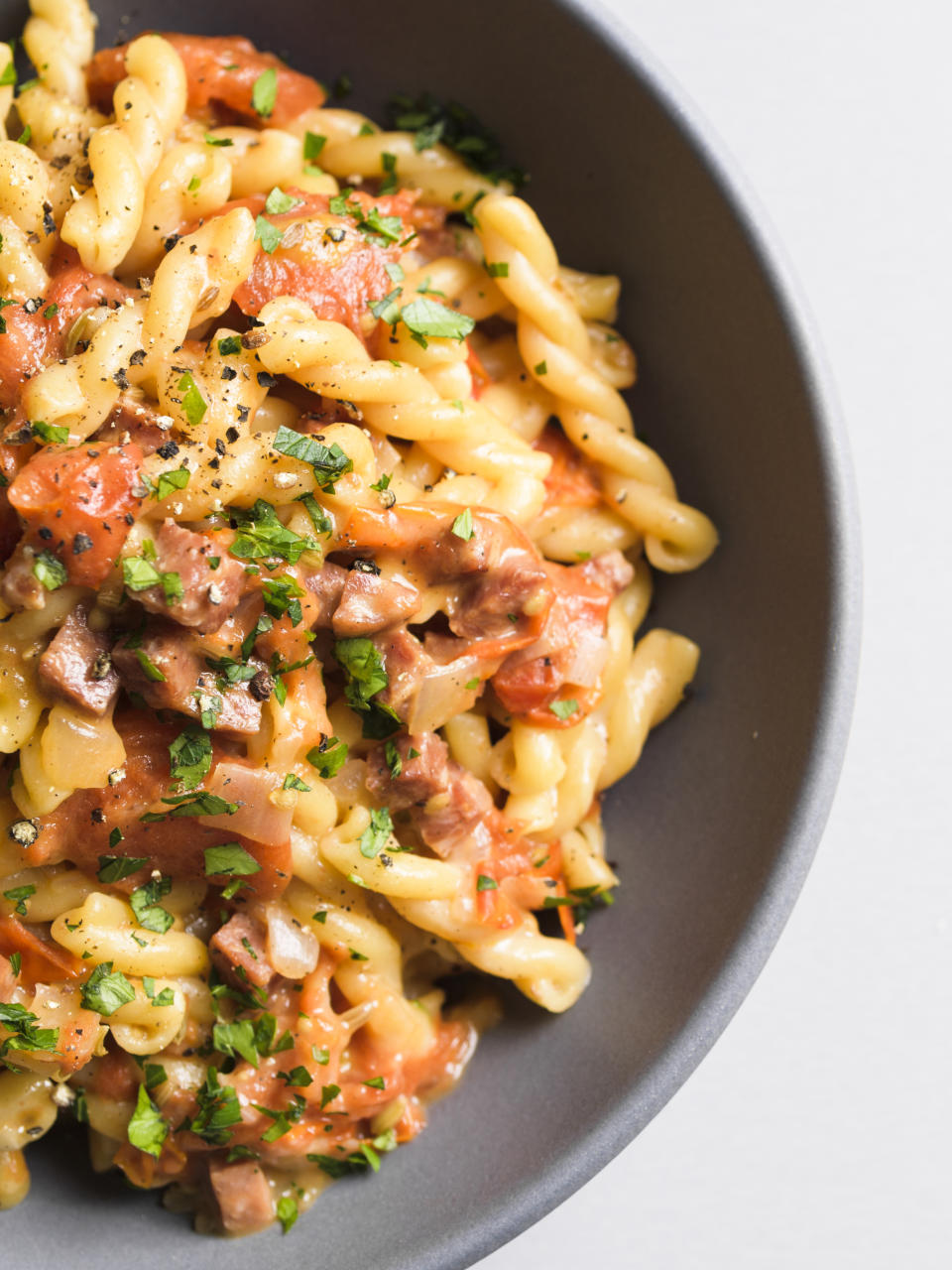This image released by Milk Street shows a recipe for Gemelli w/Tomatoes, Salami and Fontina. (Milk Street via AP)