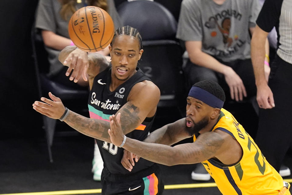 San Antonio Spurs forward DeMar DeRozan, left, passes the ball as Utah Jazz forward Royce O'Neale, right, defends in the first half during an NBA basketball game Monday, May 3, 2021, in Salt Lake City. (AP Photo/Rick Bowmer)