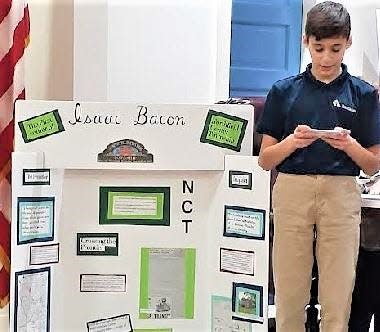 St. Barnabas student Lorenzo LaGuardia talks about Isaac Bacon, the first known settle of the Northfield area, at the Northfield Center Township trustees’ meeting March 6.