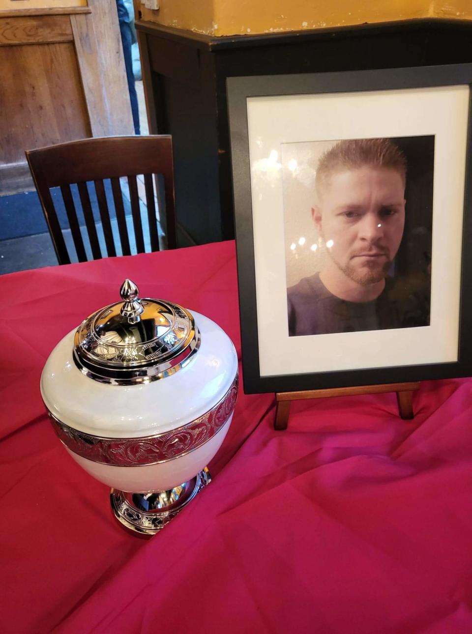 A photo of Richard Ward and an urn with his ashes can be seen on a table.