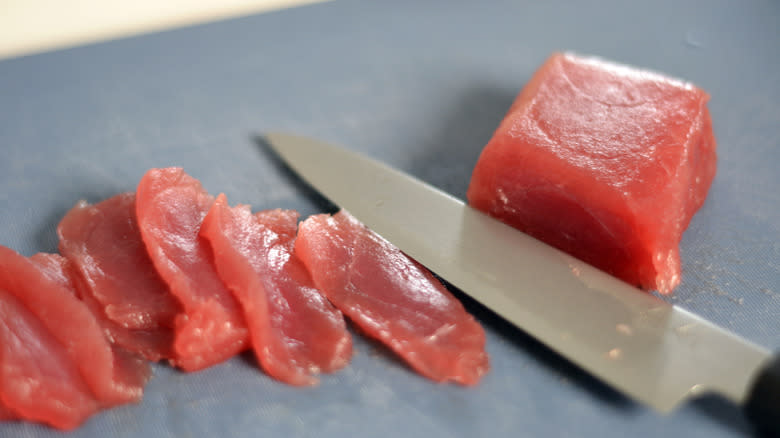 Slices of raw tuna on cutting board