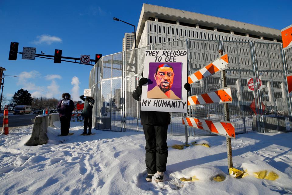 A protester stands outside a federal courthouse in St Paul, Minnesota on 24 January. (REUTERS)