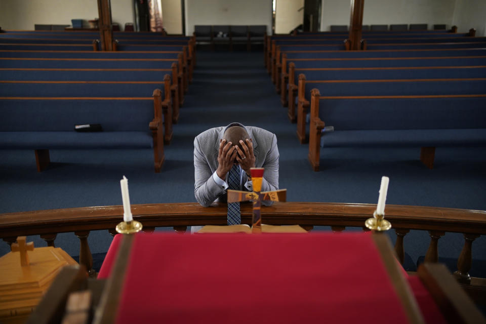 In this May 28, 2021, photo, Rev. Robert R.A. Turner, pastor of the historic Vernon African Methodist Episcopal Church, prays in the sanctuary of the church between meetings around centennial commemorations of the Tulsa Race Massacre in Tulsa, Okla. Only the basement remained of the church, partially destroyed in the massacre in 1921 that destroyed the area known as Black Wall Street. (AP Photo/John Locher)