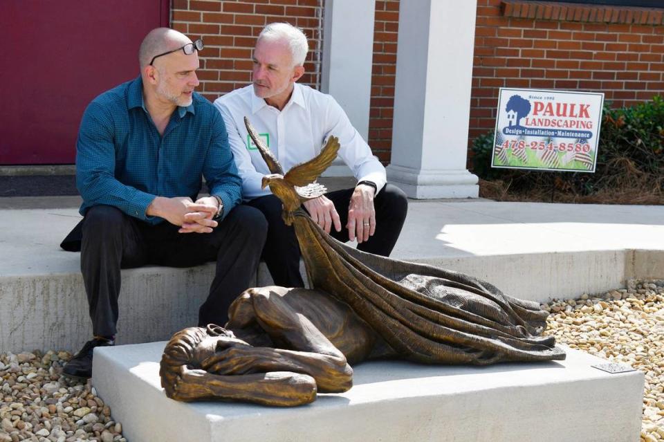 “Sheltering” sculptor Timothy Schmalz (left) sits and talks with Macon Housing Authority Chair Jeff Battcher after the blessing of the new Central City Apartments and Sheridan Health Center on Monday, May 20, 2024, in Macon, Georgia. The new complex will be comprised of 82 beds of affordable housing and a 12 bed medical respite.