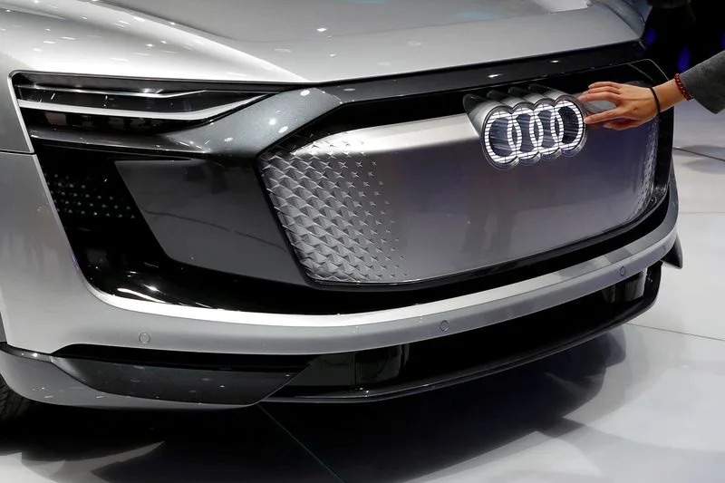 FILE PHOTO: Woman touches logo on Audi e-tron Sportback concept car at the Shanghai Auto Show during its media day, in Shanghai