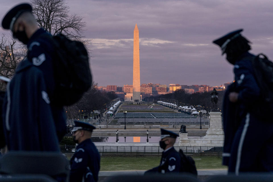 The Washington Monument and the National Mall are visible as members of the U.S. Air Force Honor Guard walk along the West Front of the U.S. Capitol at the site of the 59th Presidential Inauguration in Washington, Monday, Jan. 18, 2021. (AP Photo/Andrew Harnik)