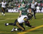 Hamilton Tiger-Cats quarterback Henry Burris (1) falls into the endzone to score a touchdown as Saskatchewan Roughriders Craig Butler (28) looks on during the second half of the CFL's 101st Grey Cup championship football game in Regina, Saskatchewan November 24, 2013. REUTERS/Todd Korol (CANADA - Tags: SPORT FOOTBALL)