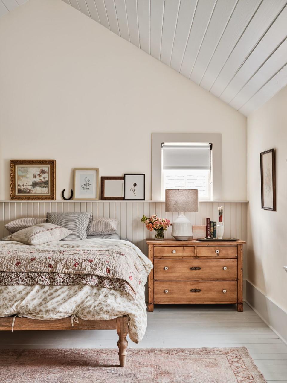 a texas farmhouse bedroom with v groove paneling and neutral colors