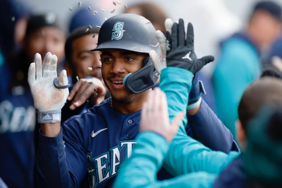 Mariners center fielder Julio Rodriguez celebrates in the dugout after hitting a two-run home run during the sixth inning, Friday, April 7, 2023, in Cleveland.