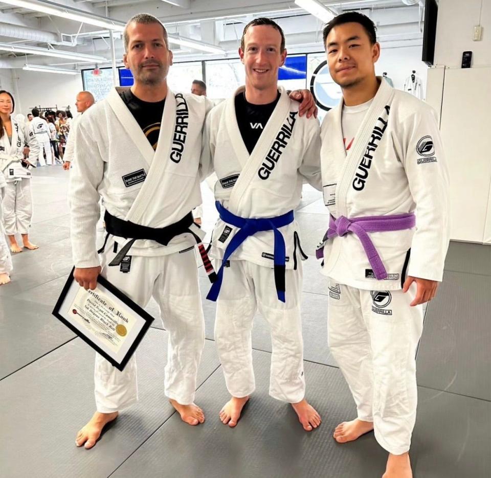 Mark Zuckerberg, center, poses with two men, including his trainer, Dave Camarillo, left.