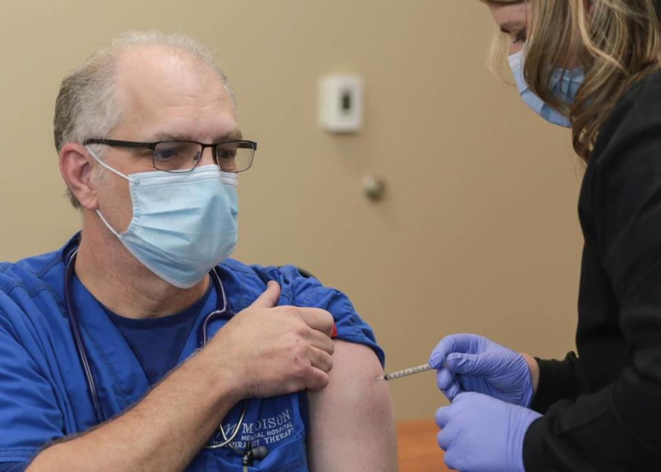 Respiratory therapist Danny Wilson receives a dose of the Pfizer-BioNTech vaccine in Rexburg. Idaho companies with 100 or more employees would be required to have all workers vaccinated or showing up-to-date negative COVID-19 tests under an order announced Thursday by President Joe Biden.