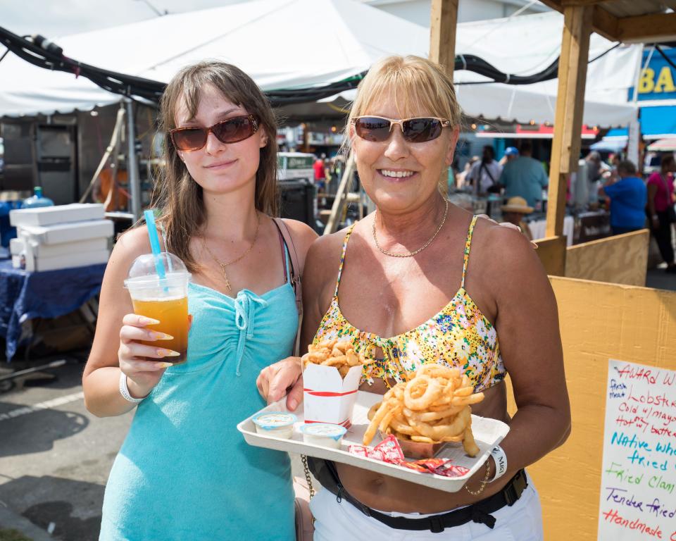Kate and Mary Boulanger, of Western, Massachusetts, with fried clams and onion rings at the 34th Hampton Beach Seafood Festival on Saturday, Sept. 9, 2023.
