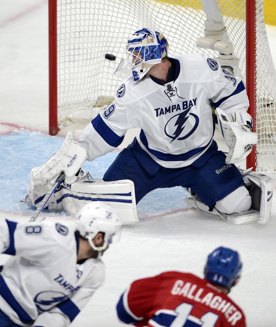 Montreal Canadiens right wing Brendan Gallagher (11) scores the third goal against Tampa Bay Lightning goalie Anders Lindback (39) as Tampa Bay Lightning defenseman Mark Barberio (8) looks on during second period National Hockey League Stanley Cup playoff action on Tuesday, April 22, 2014 in Montreal. (AP Photo/The Canadian Press, Ryan Remiorz)