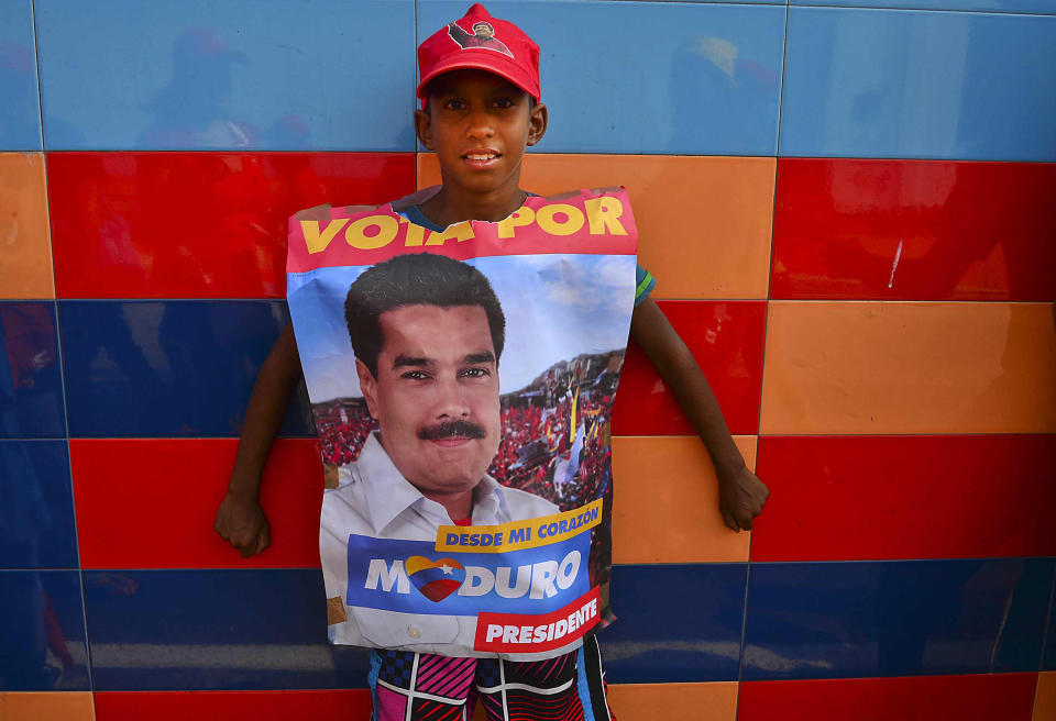Un joven partidario del candidato oficialista a la presidencia de Venezuela, Nicolás Maduro, acude a su mitin en Vargas, este martes.