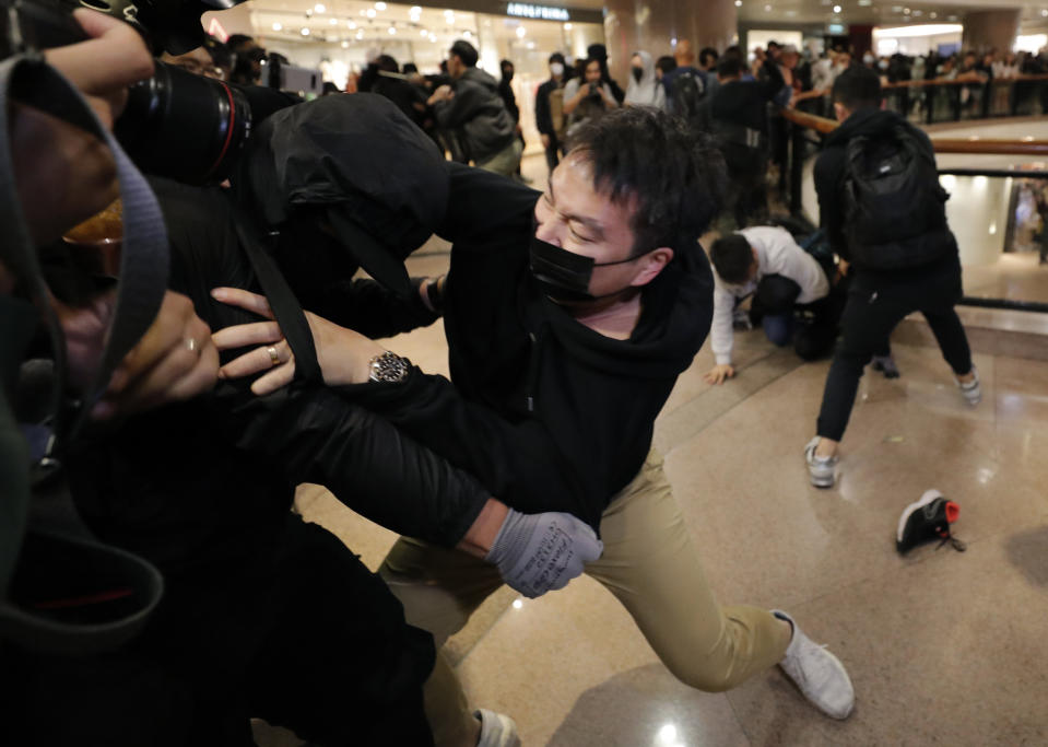 Plain clothed police officers arrest protesters in a mall during Christmas Eve in Hong Kong, Tuesday, Dec. 24, 2019. Thousands of people took to the streets on Christmas eve in Hong Kong to press the government to response to their five demands. (AP Photo/Lee Jin-man)