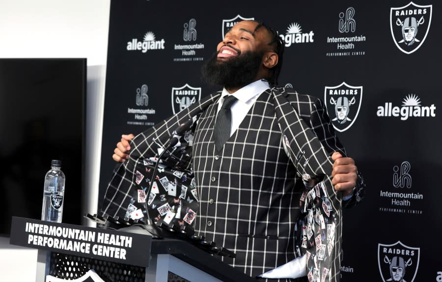 Las Vegas Raiders defensive tackle Christian Wilkins displays a jacket with a playing card design in the liner during an NFL football news conference, Thursday, March 14, 2024, in Henderson, Nev. (Steve Marcus/Las Vegas Sun via AP)