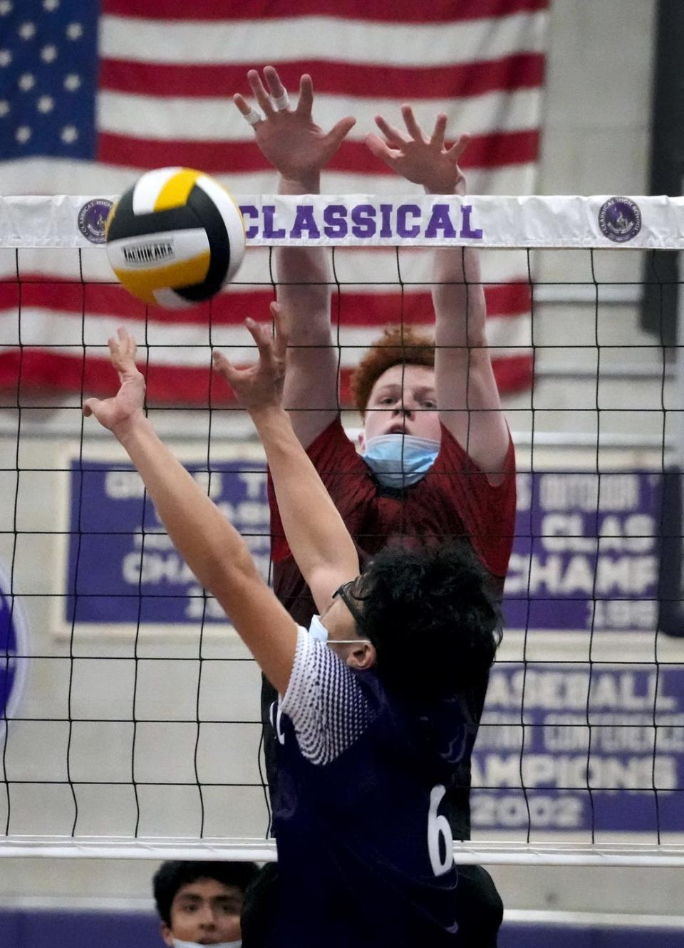 Logan Voelker goes up on the net to readying to stop the Purple's James Men during a match in 2022.