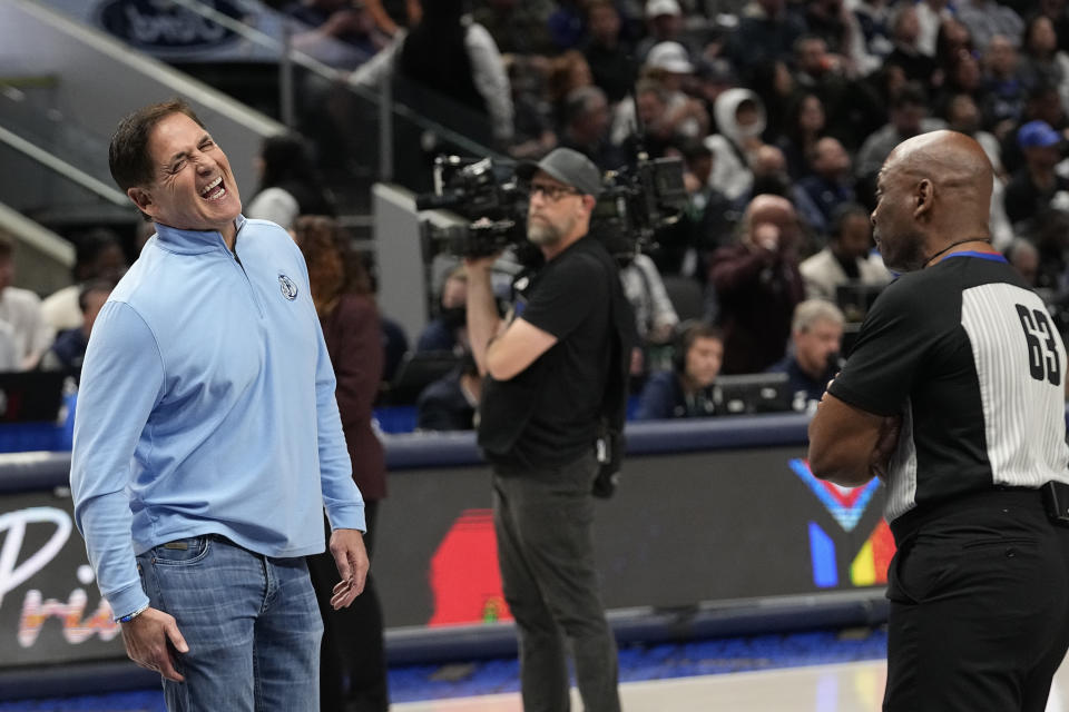 Dallas Mavericks owner Marc Cuban, left, laughs at a comment from referee Derek Richardson (63) during the first half of an NBA basketball game against the Oklahoma City Thunder in Dallas, Saturday, Dec. 2, 2023. (AP Photo/LM Otero)