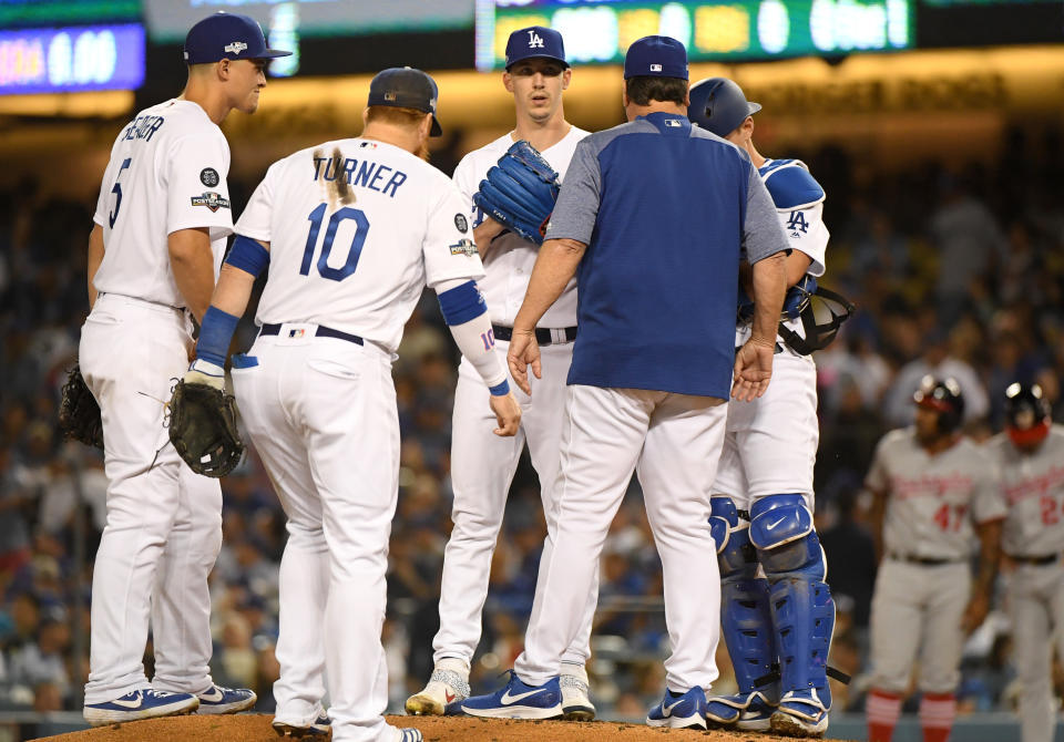 LOS ANGELES, CALIFORNIA - OCTOBER 03: Starting pitcher Walker Buehler #21 of the Los Angeles Dodgers gets a visit from pitching coach Rick Honeycutt during the fourth inning of game one of the National League Division Series against the Washington Nationals at Dodger Stadium on October 03, 2019 in Los Angeles, California. (Photo by Harry How/Getty Images)