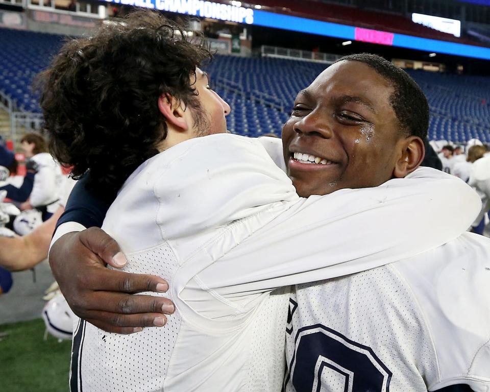 Tears of joy stream down the cheeks of Austin Clarke while being hugged by PJ Celestino following their 23-13 win over Abington in the Division 6 state title game at Gillette Stadium in Foxboro on Friday, Dec. 3, 2021.