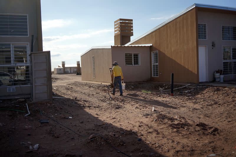 A worker carries tools at the construction site of a housing complex, in Anelo