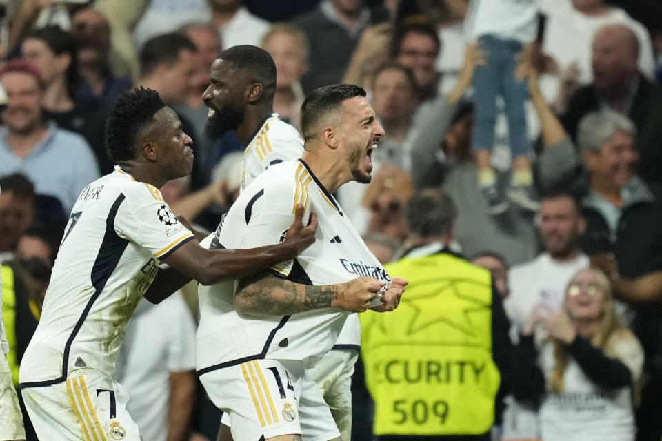 Real Madrid's Joselu, right, celebrates with his teammates after scoring his side's opening goal during the Champions League semifinal second leg soccer match between Real Madrid and Bayern Munich at the Santiago Bernabeu stadium in Madrid, Spain, Wednesday, May 8, 2024. (AP Photo/Jose Breton)