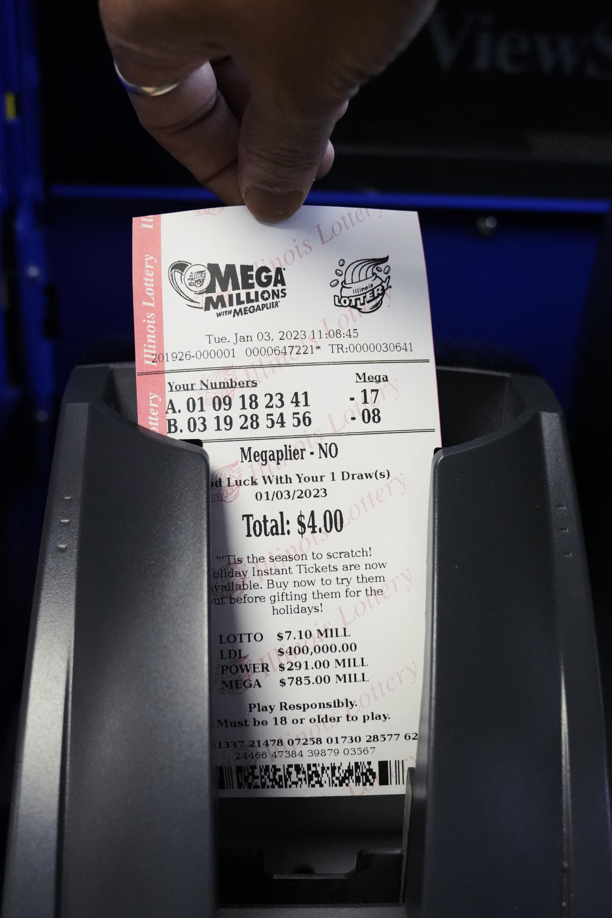 A Mega Millions lottery ticket is printed out of a lottery machine at a convenience store Tuesday, Jan. 3, 2023, in Northbrook, Ill. (AP Photo/Nam Y. Huh)