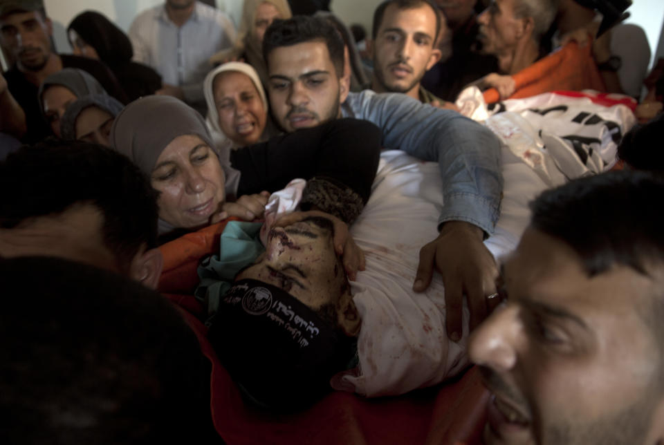 Relatives of Palestinian Naji Zaanin, 25, who was killed in an Israeli airstrike, mourn over his body in the family home during his funeral in town of Beit Hanoun, northern Gaza Strip, Wednesday, Oct. 17, 2018. (AP Photo/ Khalil Hamra)