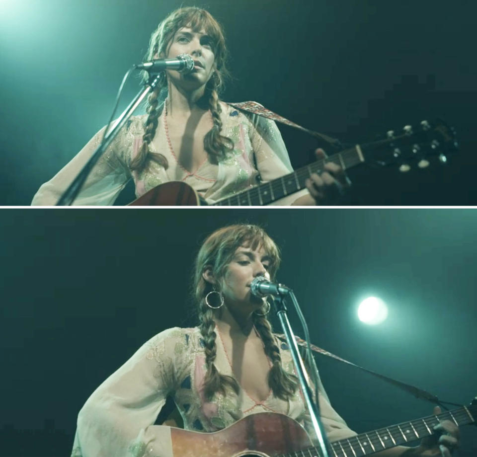 Daisy Jones playing guitar and singing into a microphone onstage