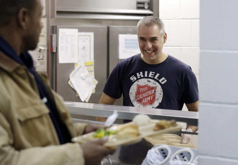 In this Nov. 14, 2013 photo, chef Jeff Ansorge talks with a man who was served lunch at the Salvation Army Eastside Corp Community Center in St. Paul, Minn. Ansorge, who used to command a staff of 17 at a posh downtown Minneapolis restaurant making nearly $80,000 a year, gave it all up to become the cook in charge of a Salvation Army soup kitchen where the meals are free. (AP Photo/Jim Mone)