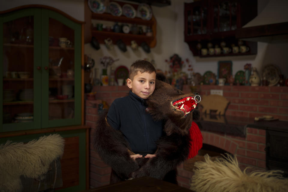 Razvan, 11 years-old, a member of the Sipoteni bear pack, poses for a portrait in Comanesti, northern Romania, Wednesday, Dec. 27, 2023. Razvan first wore the bear fur costume when he was 9 years-old, likes the feeling he gets from wearing it and loves to dance. (AP Photo/Andreea Alexandru)