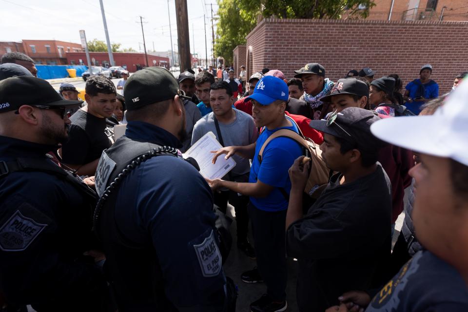 Migrants ask El Paso Police about documents they received after crossing to the U.S. outside Sacred Heart Church in Downtown El Paso on Friday, April 28, 2023.