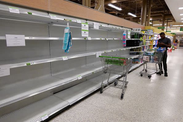 A person stands in an empty water aisle in a grocery store as people stock up on necessary items in prepartation for the possible arrival of Hurricane Ian on September 26, 2022, in St. Petersburg, Florida.