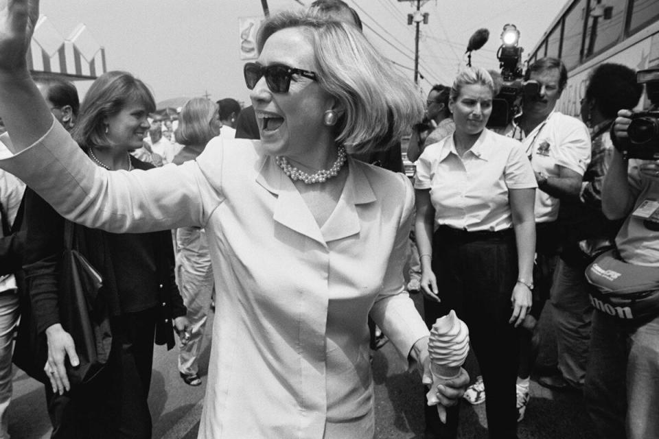 With an ice cream cone in hand, Hillary waves to the crowd in Weedsport, New York, as she heads to the Harriet Tubman Home for the Aged in Auburn, New York, one of the stops on her Save America's Treasures tour, July 14, 1998.