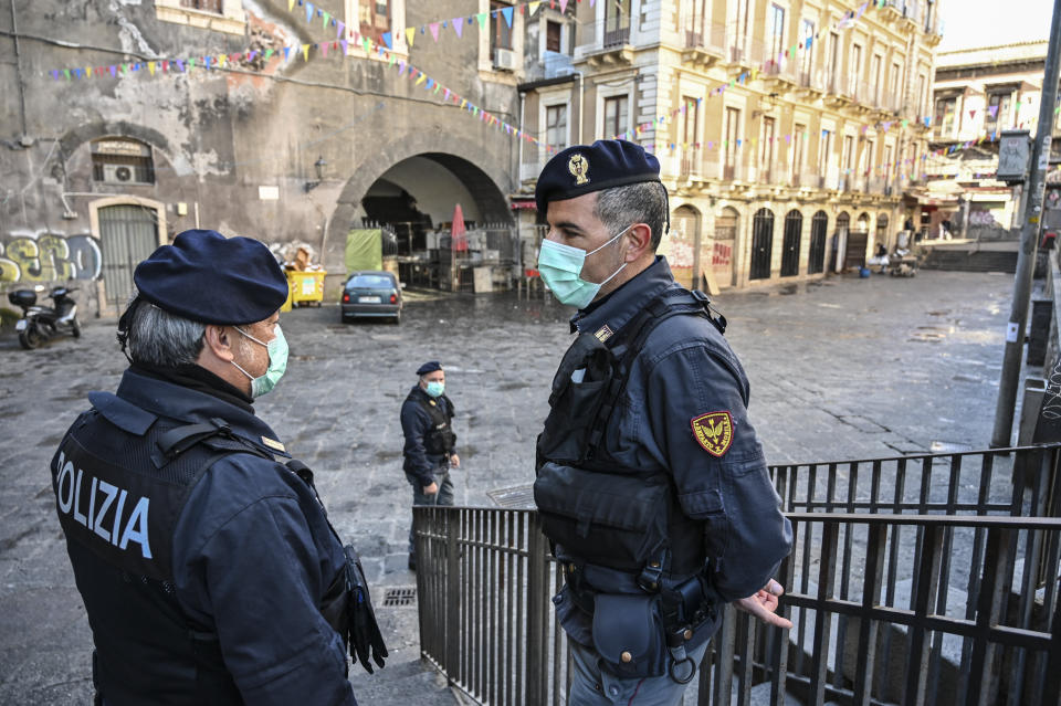 Police with the protective masks control the traditional open-air fish market closed due to the coronavirus emergency on March 12 in Catania, Italy. (Photo: Fabrizio Villa via Getty Images)