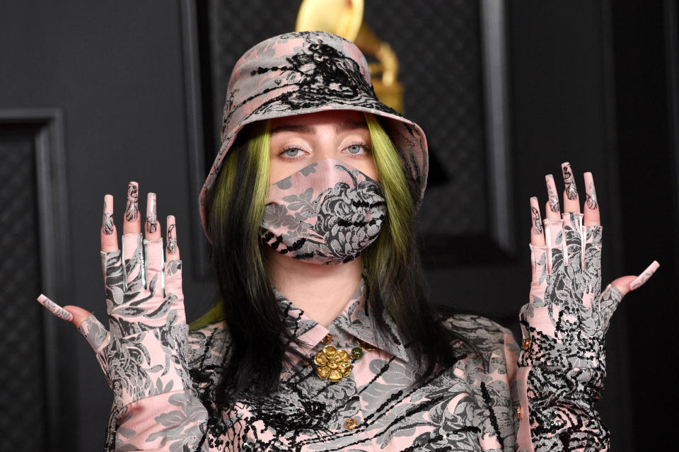 Billie showing off her floral printed nails that match her top, bucket hat, and face mask at the Grammys