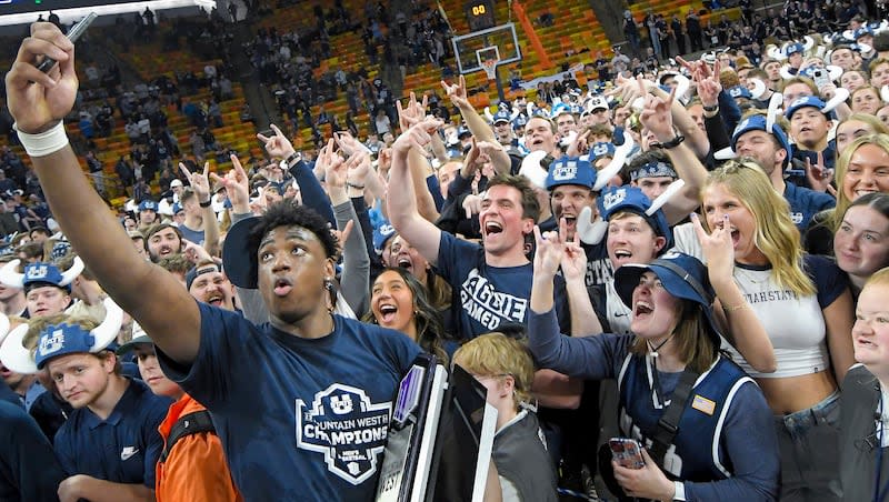 Utah State forward Great Osobor celebrates with fans after the team's win over New Mexico Saturday, March 9, 2024, in Logan, Utah. The victory clinched the Mountain West Conference regular-season championship for Utah State.