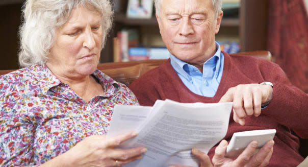 Worried Senior Couple Looking At Bills Together