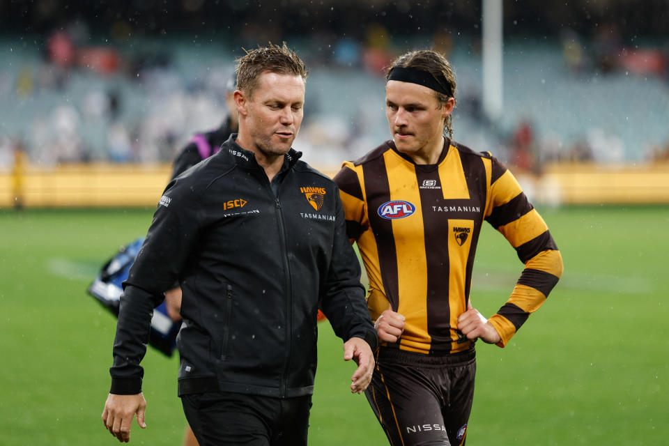 MELBOURNE, AUSTRALIA - APRIL 01: Sam Mitchell, Senior Coach of the Hawks and Jack Ginnivan of the Hawks are seen after a loss during the 2024 AFL Round 03 match between the Hawthorn Hawks and the Geelong Cats at the Melbourne Cricket Ground on April 01, 2024 in Melbourne, Australia. (Photo by Dylan Burns/AFL Photos via Getty Images)