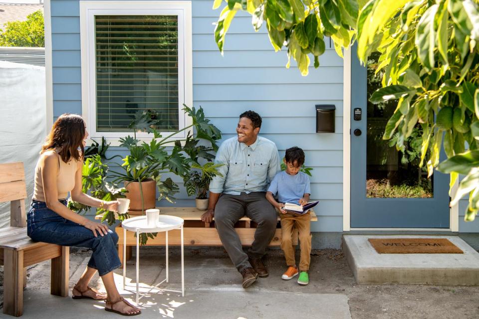 A man and a woman sit outside with their young son