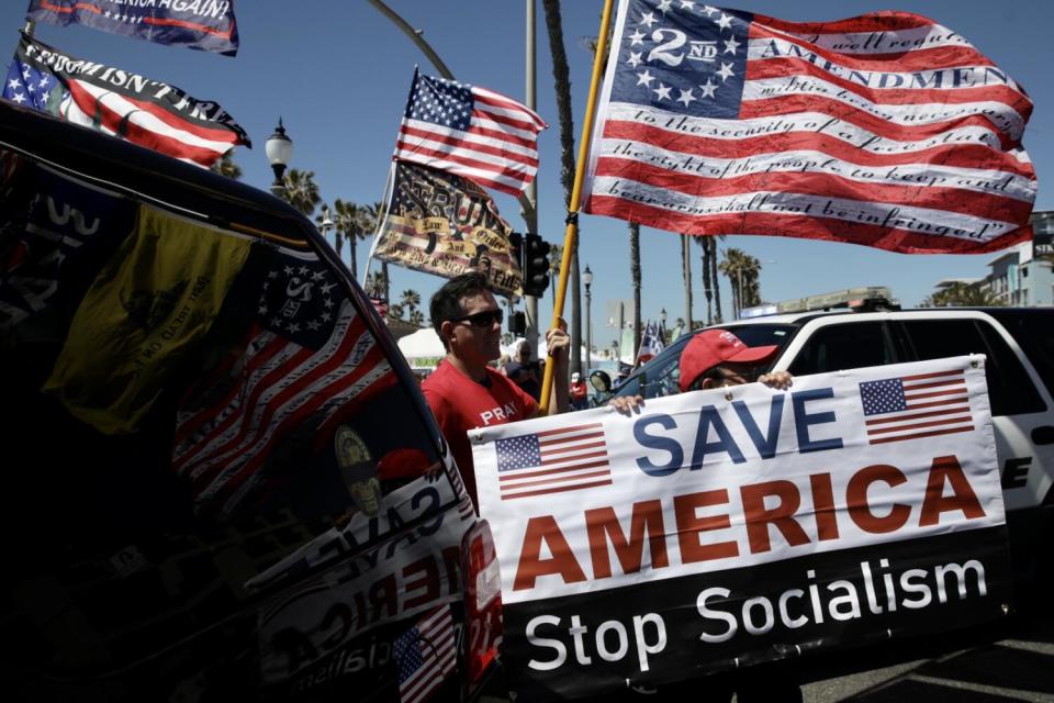 Pro-Trump demonstrators with flags and a sign that says, "Save America -- Stop Socialism"