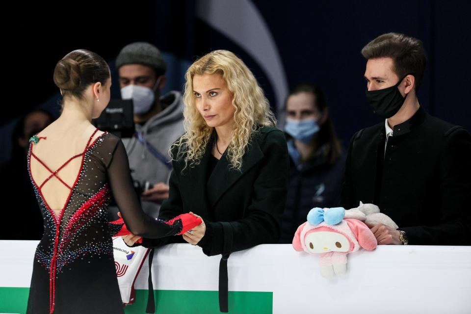 A woman stairs into the eyes of a younger skater, whose back is to the camera.